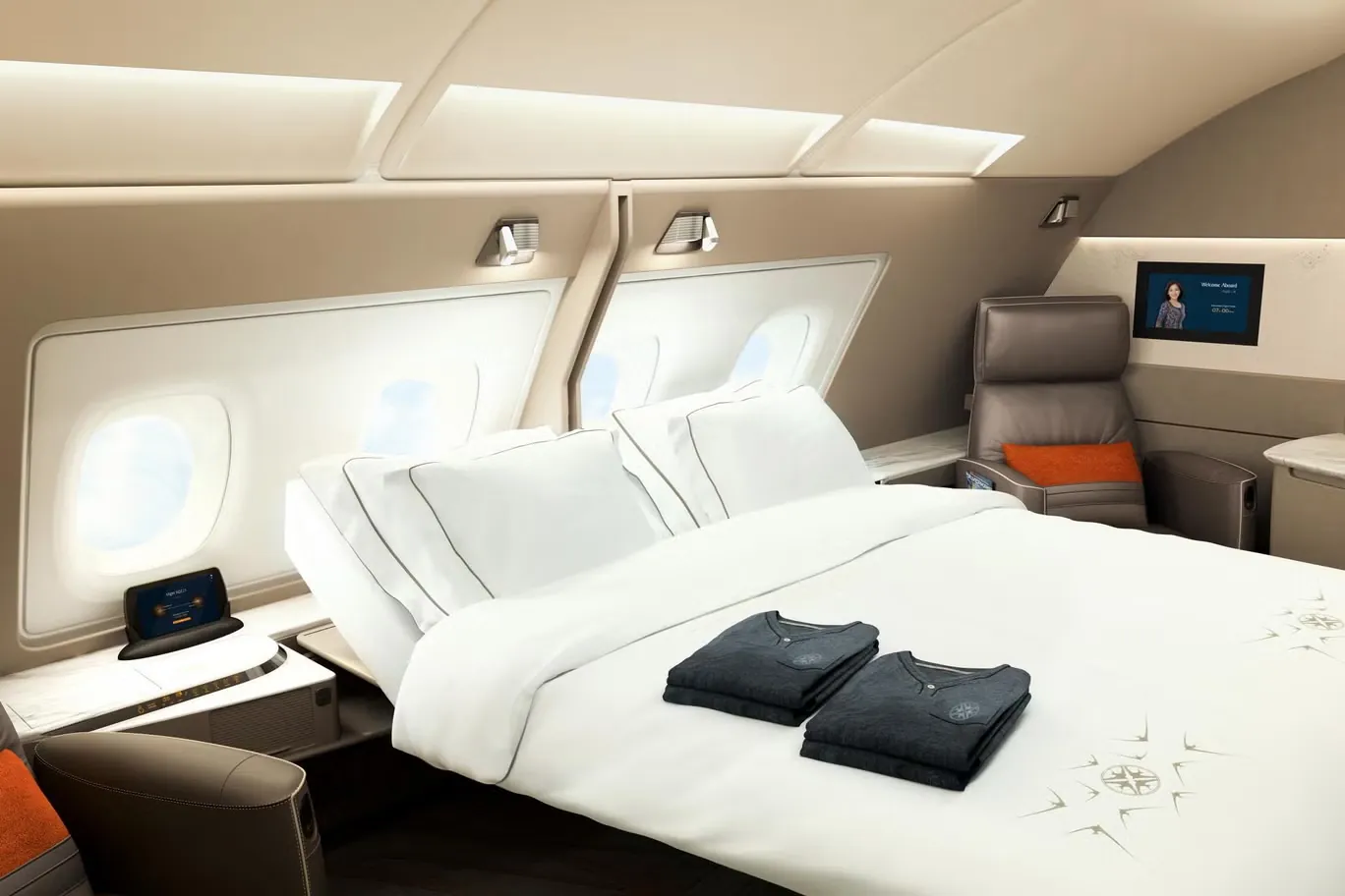 Eine First-Class-Suite mit Doppelbett, weißer Bettwäsche und Fenstern an Bord eines Großraumflugzeugs